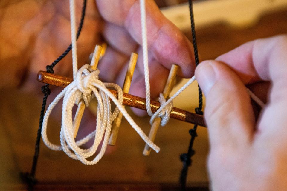 Andy Baum demonstrates how he puts up the sails on his radio-controlled boat, which is fashioned after a schooner at the turn of the last century.