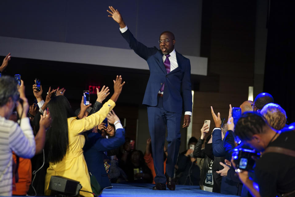 Sen. Raphael Warnock waves to the crowd at an election night party.