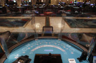 Acrylic barriers separate player's seats as a coronavirus safety precaution at a blackjack table in the closed Bellagio hotel and casino, Wednesday, May 20, 2020, in Las Vegas. Casino operators in Las Vegas are awaiting word when they will be able to reopen after a shutdown during the coronavirus outbreak. (AP Photo/John Locher)