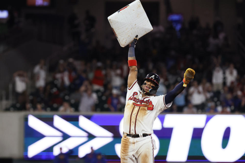 Atlanta Braves' Ronald Acuña Jr. (13) holds up the base after stealing second against the Chicago Cubs during the 10th inning of a baseball game Wednesday, Sept. 27, 2023, in Atlanta. It was Acuña's 70th stolen base of the season. (Miguel Martinez/Atlanta Journal-Constitution via AP)