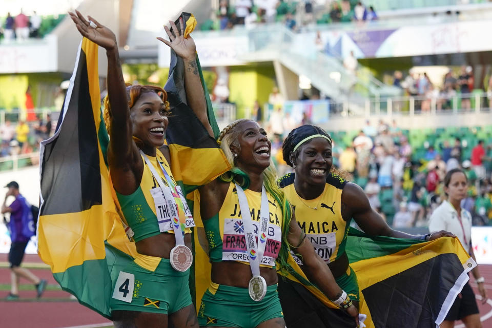 Gold medalist Shelly-Ann Fraser-Pryce, of Jamaica, center, stands with silver medalist Shericka Jackson, of Jamaica, right, and bronze medalist Elaine Thompson-Herah, of Jamaica, wave after a medal ceremony for the final in the women's 100-meter run at the World Athletics Championships on Sunday, July 17, 2022, in Eugene, Ore. (AP Photo/Ashley Landis)