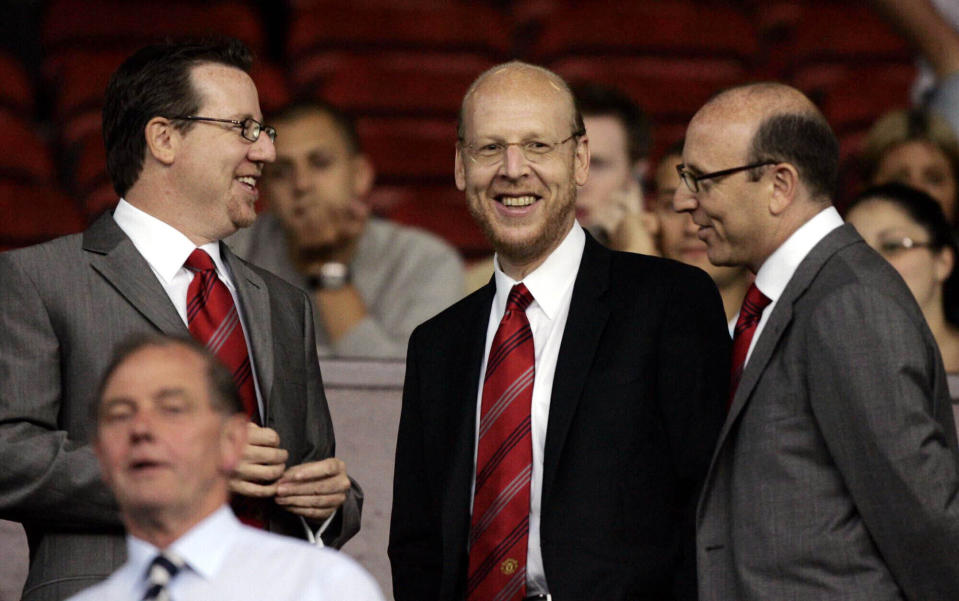 ARCHIVO - Foto del 9 de agosto del 2005, los integrantes de la junta directiva del Manchester United Bryan Glazer, Avi Glazer y Joel Glazer toman sus asientos en el Odl Trafford antes del encuentro ante el Debrecen en la Liga de Campeones. El martes 22 de noviembre del 2022, la familia Glazers busca atraer inversión para el equipo y explora la posibilidad de vender al equipo. (AP Foto/Jon Super, Archivo)