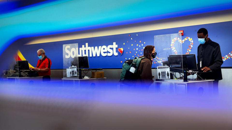Travelers line up at the Southwest Airlines counter at the airport.<p>Kevin Dietsch/Getty Images</p>