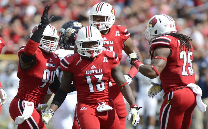 Sep 21, 2013; Louisville, KY, USA; Louisville Cardinals defensive end Lorenzo Mauldin (94) and safety Calvin Pryor (25) celebrate the 3rd down stop of linebacker James Burgess (13) against the FIU Golden Panthers during the first quarter of play at Papa John'sCardinal Stadium. Mandatory Credit: Jamie Rhodes-USA TODAY Sports