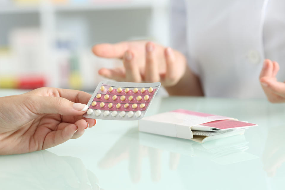 A woman picking up birth control at the pharmacy