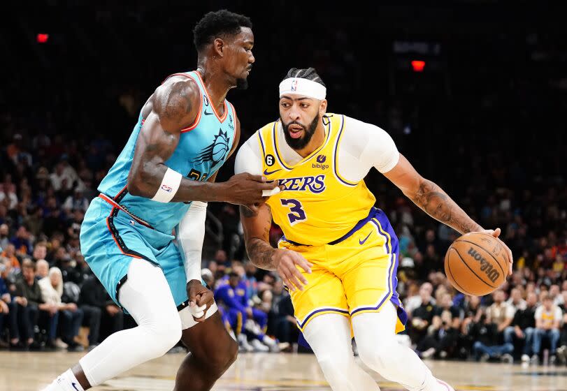 Los Angeles Lakers' Anthony Davis (3) tries to get around Phoenix Suns' Deandre Ayton during the first half of an NBA basketball game in Phoenix, Tuesday, Nov. 22, 2022. (AP Photo/Darryl Webb)