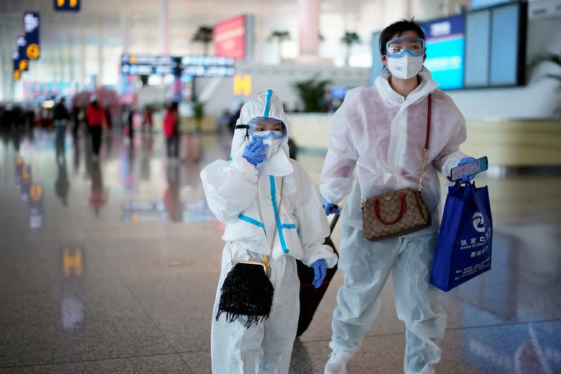 People wearing protective gear are seen at the Wuhan Tianhe International Airport