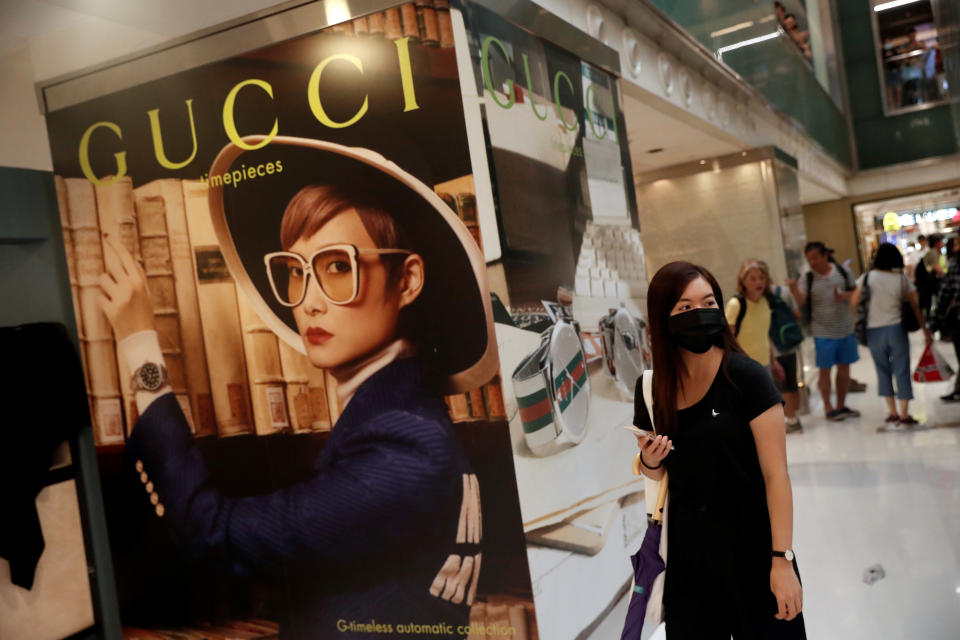 A woman walks past a Gucci advertising poster as shoppers and anti-government protesters gather at New Town Plaza in Sha Tin, Hong Kong, China November 3, 2019. REUTERS/Shannon Stapleton