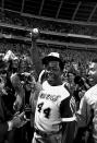 FILE - Hank Aaron holds aloft the ball he hit for his 715th career home run, against the Los Angeles Dodgers in Atlanta, Ga., Monday night, April 8, 1974. Just in time for the 50-year anniversary of Hank Aaron's record 715th home run, Charlie Russo is making available video he shot of the homer.(AP Photo/Bob Daugherty, File)