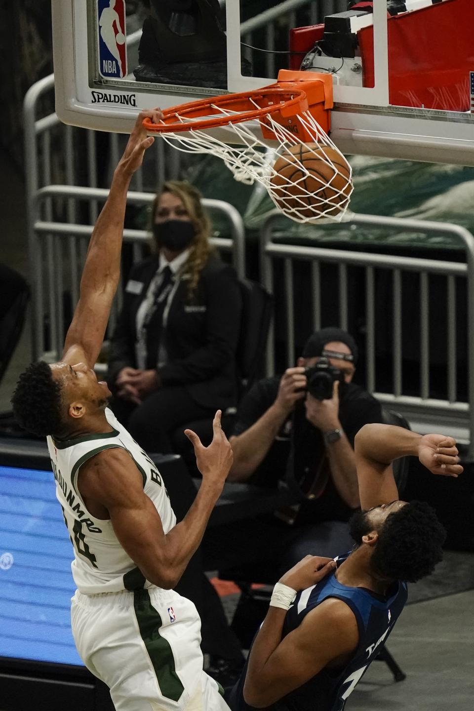 Milwaukee Bucks' Giannis Antetokounmpo dunks over Minnesota Timberwolves' Karl-Anthony Towns during the first half of an NBA basketball game Tuesday, Feb. 23, 2021, in Milwaukee. (AP Photo/Morry Gash)