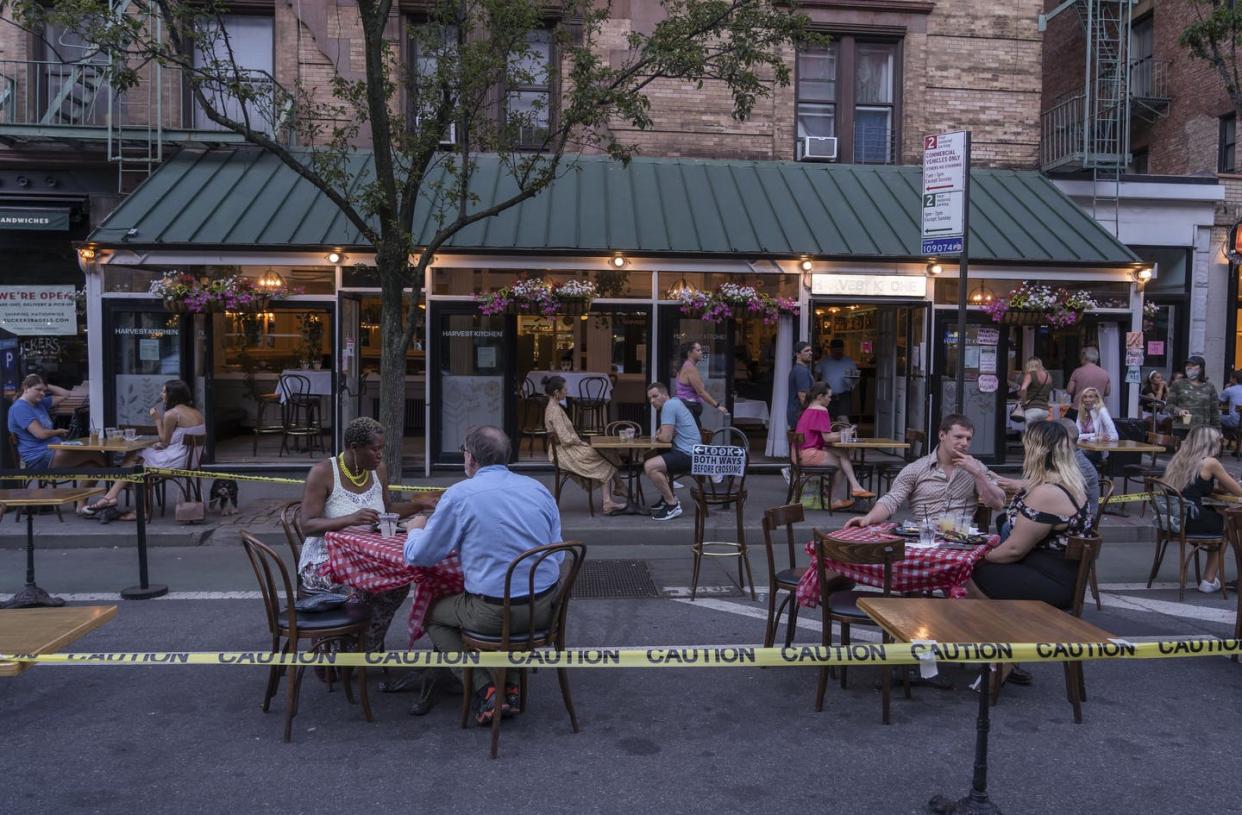 <span class="caption">Harvest Kitchen restaurant, on Manhattan's Upper West Side, making use of New York City's new policy of opening streets to walking, biking and dining.</span> <span class="attribution"><a class="link " href="https://www.gettyimages.com/detail/news-photo/harvest-kitchen-restaurant-has-extended-its-outdoor-area-by-news-photo/1222125975?adppopup=true" rel="nofollow noopener" target="_blank" data-ylk="slk:Ron Adar/SOPA Images/LightRocket via Getty Images;elm:context_link;itc:0;sec:content-canvas">Ron Adar/SOPA Images/LightRocket via Getty Images</a></span>