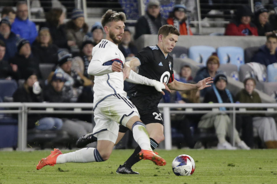 Minnesota United midfielder Will Trapp (20) and Vancouver Whitecaps midfielder Alessandro Schöpf, left, vie for ball in the second half of an MLS soccer game Saturday, March 25, 2023, in St. Paul, Minn. (AP Photo/Andy Clayton-King)