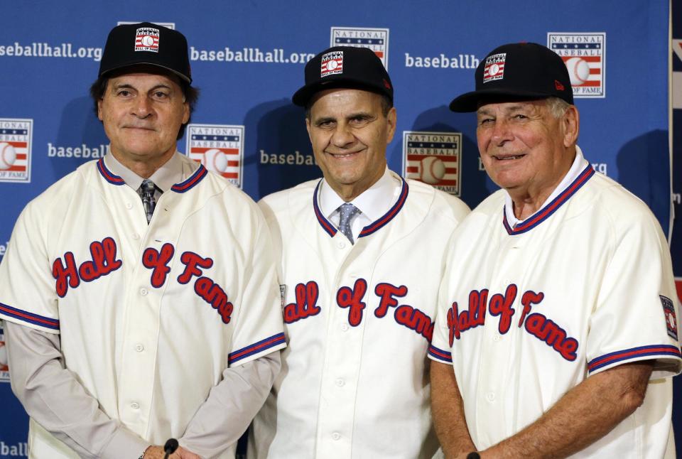 FILE - In this Dec. 9, 2013, file photo, retired managers, from left, Tony La Russa, Joe Torre and Bobby Cox gather for a photo after it was announced that they were unanimously elected to the baseball Hall of Fame during MLB winter meetings in Lake Buena Vista, Fla. La Russa will not have any logo on his cap in his Hall of Fame plaque, the Hall said Thursday, Jan. 23, 2014. Torre's will have a Yankees logo, while Cox's whill have a Braves logo. (AP Photo/John Raoux, File)