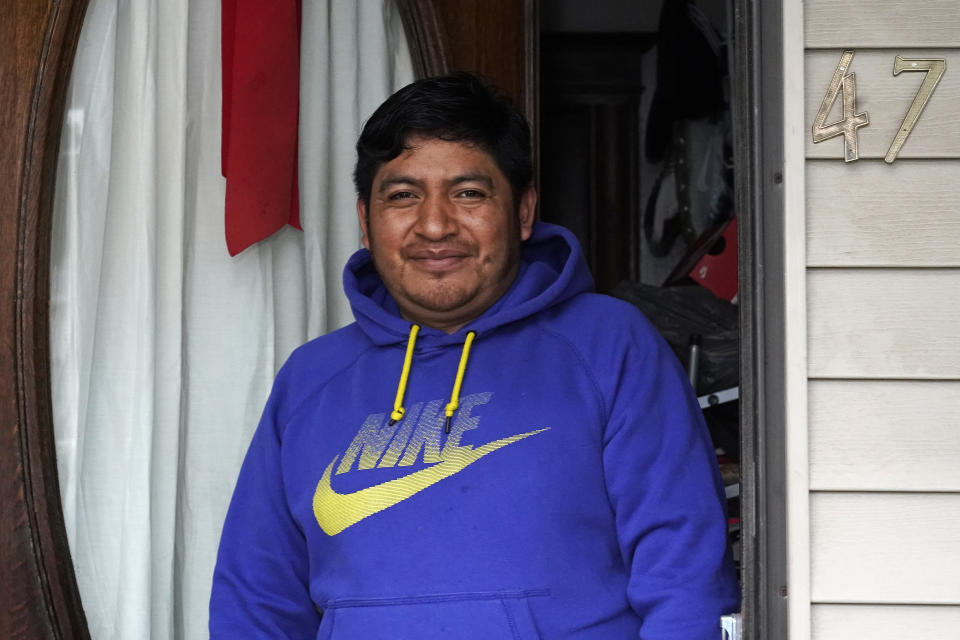 Lucio Perez poses in the front doorway of his home, where he has lived with his family since March, Thursday, July 8, 2021, in Springfield, Mass. Just a few months ago, Perez moved out of a western Massachusetts church he'd lived in for more than three years to avoid deportation. Immigration authorities in March granted the 37-year-old Guatemalan national a temporary stay in his deportation while he argued to have his immigration case reconsidered. (AP Photo/Charles Krupa)