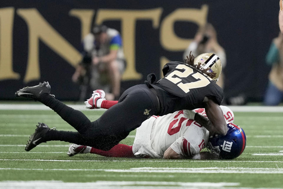 New York Giants quarterback Tommy DeVito is hit by New Orleans Saints cornerback Isaac Yiadom while sliding during the first half of an NFL football game Sunday, Dec. 17, 2023, in New Orleans. (AP Photo/Gerald Herbert)