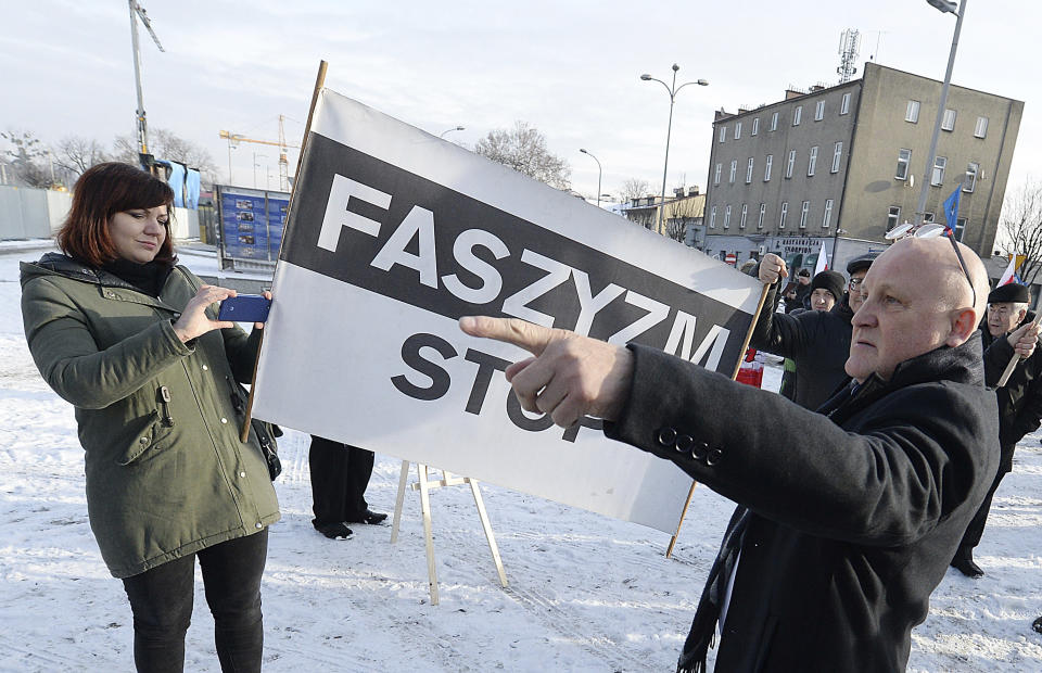 A Polish far-right activist, Piotr Rybak,right, and other nationalists gather outside the memorial site of Auschwitz in Oswiecim, Poland, on Sunday Jan. 27, 2019. Rybak has been imprisoned for burning the effigy of a Jew. He said his gatherings Sunday was an act of protest against the Polish government, which he accuses of remembering only Jews and not murdered Poles in yearly observances at the memorial site.(AP Photo/Czarek Sokolowski)