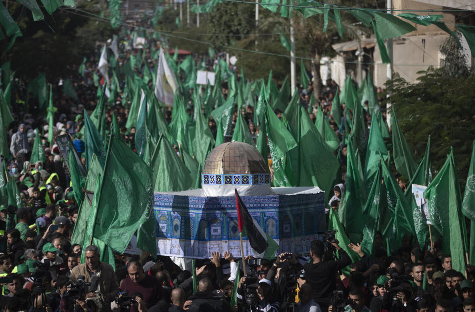 Palestinians carry a model of the Dom of the Rock mosque during a rally marking the 34th anniversary of Hamas movement's founding, in Gaza City, Friday, Dec. 10, 2021. Gaza’s Hamas rulers collect millions of dollars a month in taxes and customs at a crossing on the Egyptian border – providing a valuable source of income that helps it sustain a government and powerful armed wing. After surviving four wars and a nearly 15-year blockade, Hamas has become more resilient and Israel has been forced to accept that its sworn enemy is here to stay. (AP Photo/ Khalil Hamra)