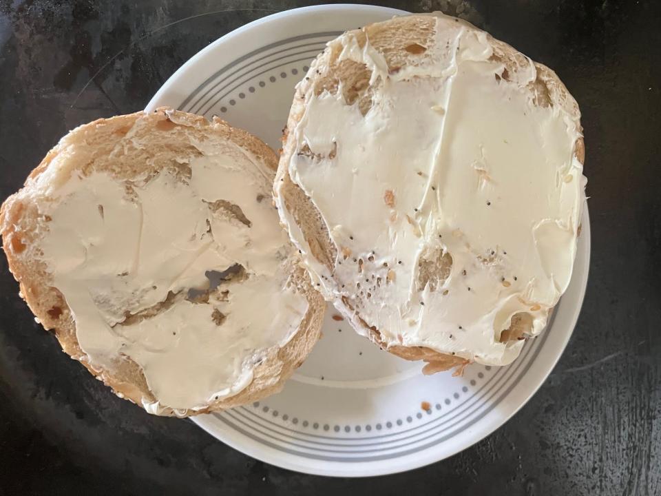 toasted bagel cut in half with cream cheese on top