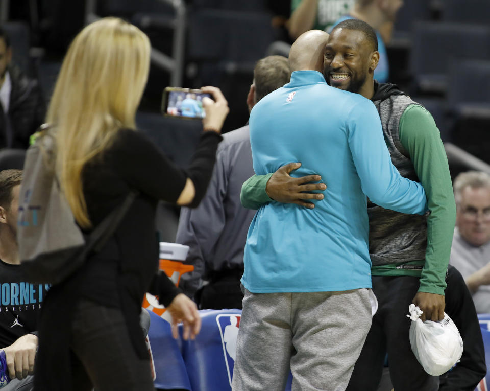 Boston Celtics' Kemba Walker, a former Charlotte Hornet, hugs old friends before an NBA basketball game between the teams in Charlotte, N.C., Thursday, Nov. 7, 2019. (AP Photo/Bob Leverone)