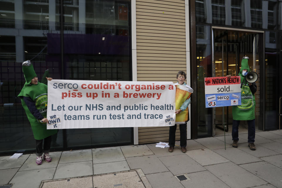 Protesters take part in a demonstration outside the Department of Health and Social Care office in London, over the private company Serco's handling of the British government's coronavirus test, track and trace system, Friday, Sept. 25, 2020. The protesters were on Friday calling for the test, track and trace system to be carried out by local public health teams who work closely with Britain's National Health Service. (AP Photo/Matt Dunham)