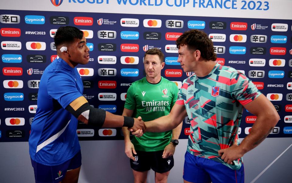 Michael Alaalatoa of Samoa shakes hands with Martin Sigren of Chile as referee Paul Williams looks on