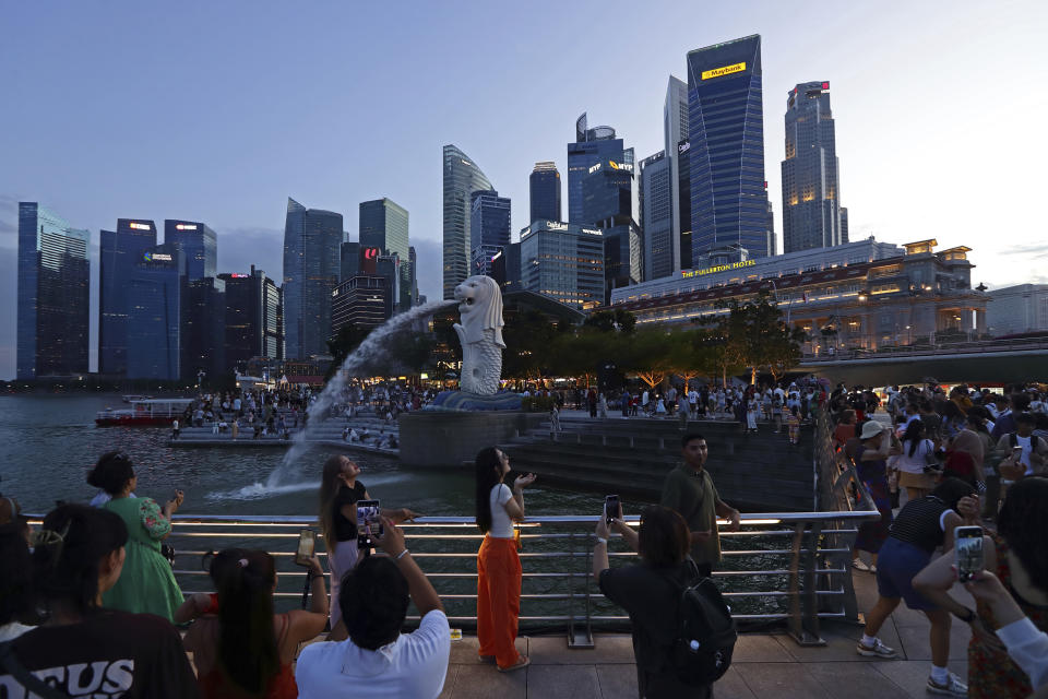 People take photos at Merlion Park in Singapore, Saturday, Sept. 7, 2024. (AP Photo/Suhaimi Abdullah)