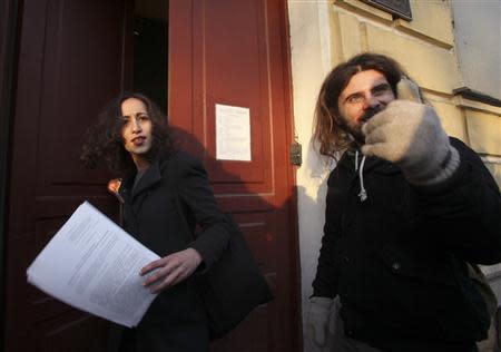 Greenpeace activist Faiza Oulahsen (L) from the Netherlands holds papers certifying the termination of prosecution after walking out of the offices of the Federal Migration Service Department in St. Petersburg, December 25, 2013. REUTERS/Stringer
