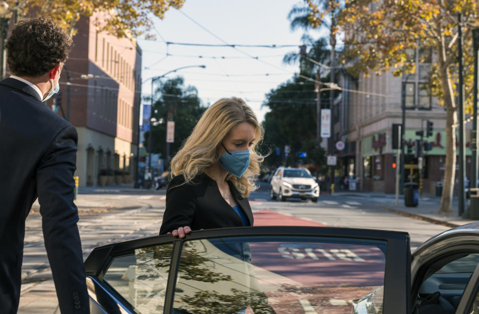 Elizabeth Holmes, center, leaves federal court in San Jose, Calif., Monday, Nov. 22, 2021. Elizabeth Holmes, the one-time medical entrepreneur now charged with building a fraudulent company based on promises of a revolutionary technology, returned to the witness stand Monday. (AP Photo/Nic Coury)