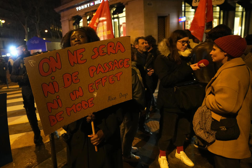 A demonstrator holds a placard reading "it's not a moment nor just a trend" outside the Olympia theater before the Cesar Awards ceremony, France's version of the Oscars, Friday, Feb. 23, 2024 in Paris. As French cinema basks in Academy Awards attention, actors who allege they were teenage victims of sexual and physical abuse by directors decades older than them are shining the light on the repulsive underside of the country's industry. The latest step in the #MeToo movement could come at the French cinema awards. (AP Photo/Michel Euler)