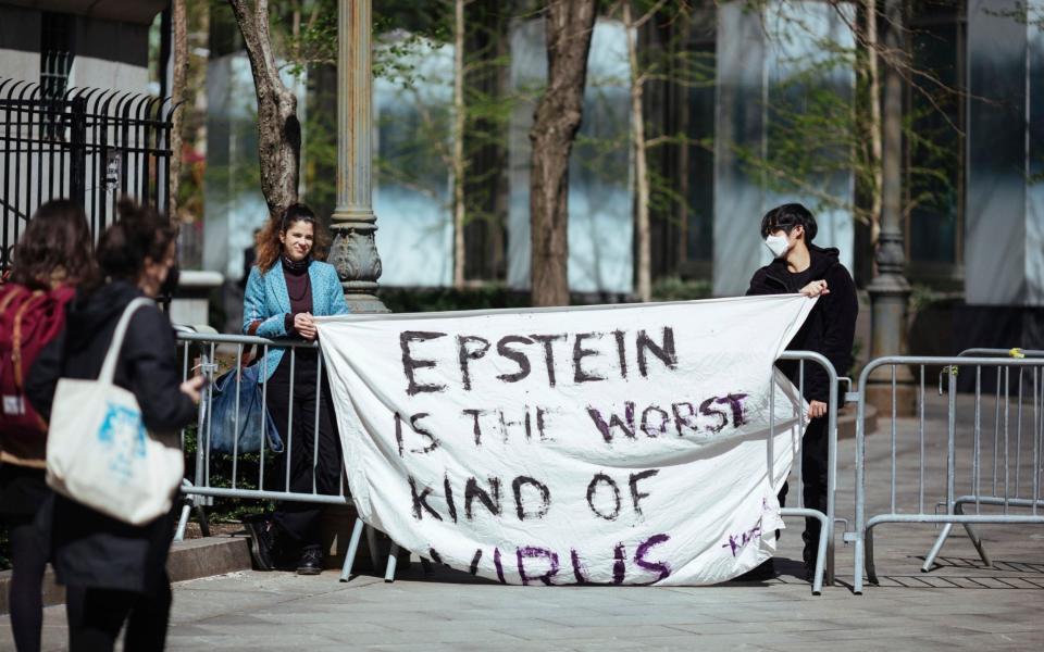 Activists protesting Jeffrey Epstein's associate Ghislaine Maxwell stand in front of the federal court in New York - AP