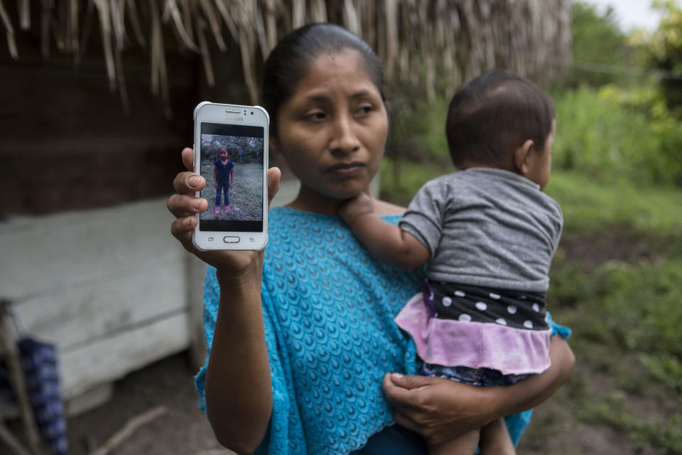 Claudia Maquin, 27, poses for a photo holding her brother-in-law’s cell phone that shows an image of her daughter Jakelin Caal, in Raxruha, Guatemala, Saturday, Dec. 15, 2018. Jakelin, 7-years-old, died in a Texas hospital, two days after being taken into custody by border patrol agents in a remote stretch of New Mexico desert. (AP Photo/Oliver de Ros)