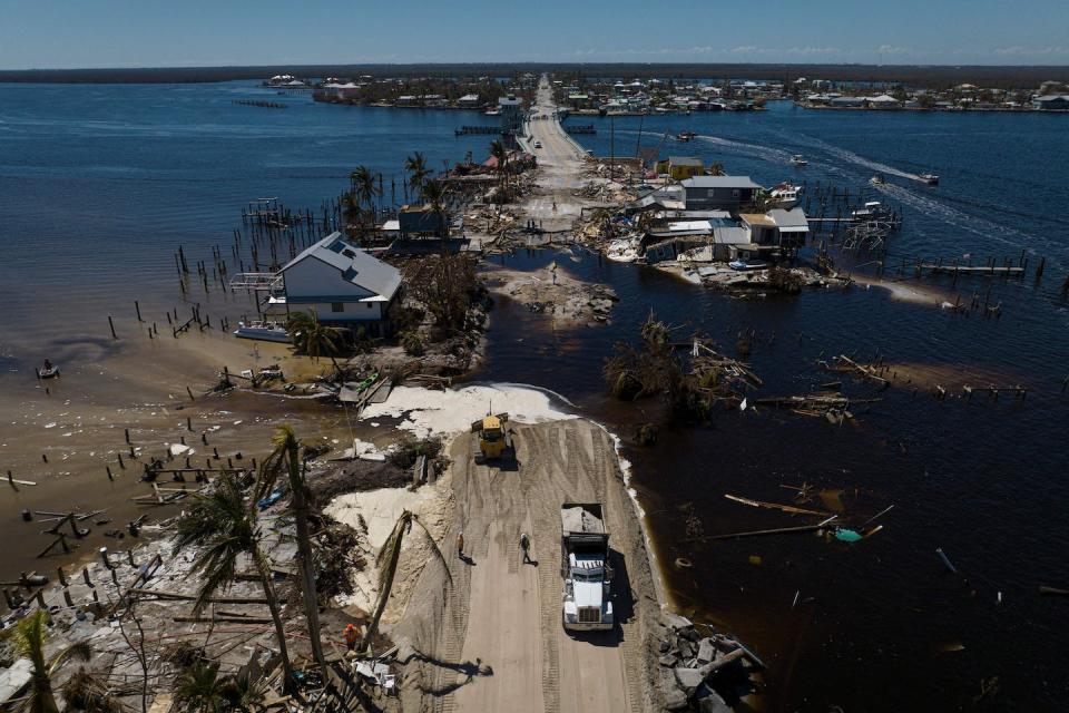 A dump truck works to repair a washed out road after Hurricane Ian hit Matlacha, Florida, on Oct. 3, 2022. <a href="https://www.gettyimages.com/detail/news-photo/an-aerial-picture-taken-on-october-3-2022-shows-a-dump-news-photo/1243707869?phrase=Matlacha&adppopup=true" rel="nofollow noopener" target="_blank" data-ylk="slk:Ricardo Arduengo/AFP via Getty Images;elm:context_link;itc:0;sec:content-canvas" class="link ">Ricardo Arduengo/AFP via Getty Images</a>