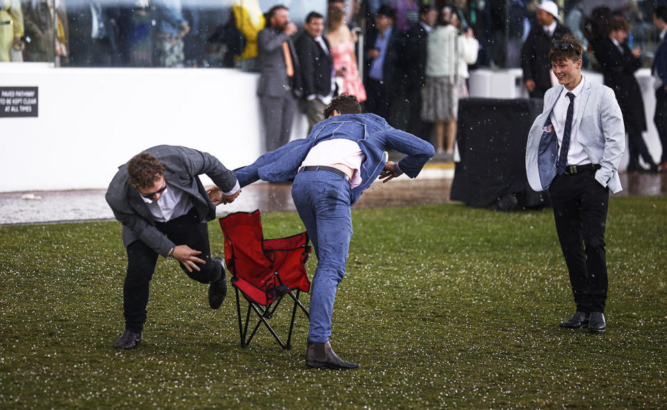 Racegoers, pictured here play-fighting during a hail storm. 