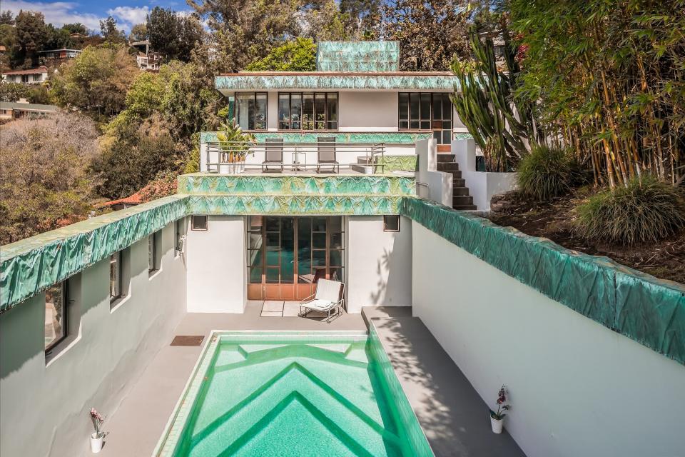 An aerial view shows the swimming pool in the backyard, as well as the back patio.