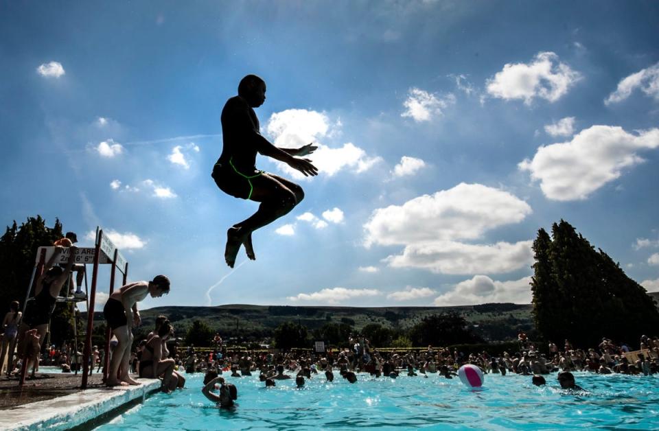 People enjoying the sun at Ilkley Lido (PA)