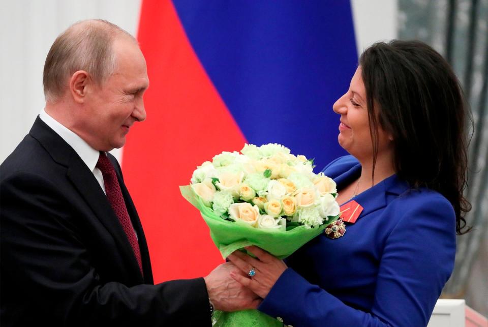 Putin presents flowers to the editor-in-chief of Russian state broadcaster RT, Margarita Simonyan, in 2019 (AFP/Getty)