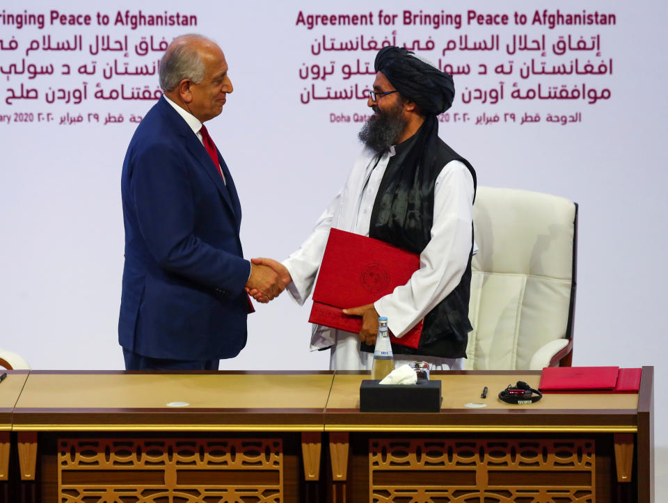 Mullah Abdul Ghani Baradar, the leader of the Taliban delegation, and Zalmay Khalilzad, U.S. envoy for peace in Afghanistan, shake hands after signing an agreement at a ceremony between members of Afghanistan's Taliban and the U.S. in Doha, Qatar February 29, 2020. REUTERS/Ibraheem al Omari