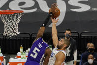 Sacramento Kings guard De'Aaron Fox, left, contests the shot of Los Angeles Clippers forward Nicolas Batum during the first quarter of an NBA basketball game in Sacramento, Calif., Friday, Jan. 15, 2021. (AP Photo/Rich Pedroncelli)