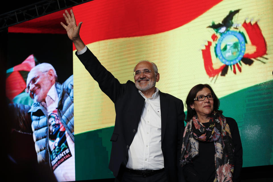 Opposition candidate Carlos Mesa waves to supporters, accompanied by his wife Elvira Salinas, after the first round presidential election in La Paz, Bolivia, Sunday, Oct. 20, 2019.Mesa will face President Evo Morales in a December election runoff. (AP Photo/Juan Karita)