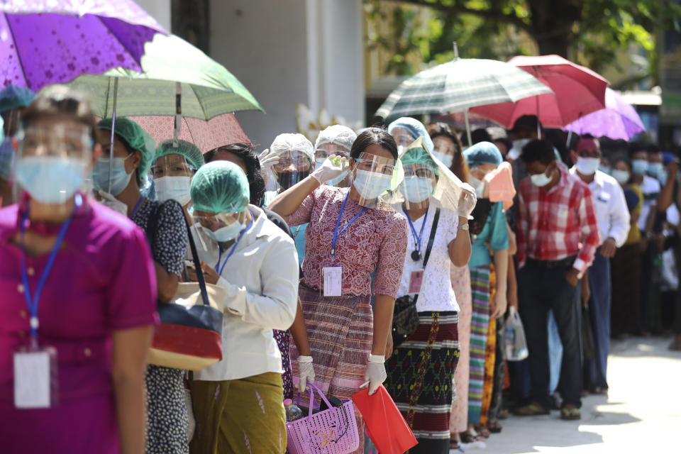 Voters wearing protective face masks to help curb the spread of the coronavirus line up to cast their ballots at a polling station near Shwedagon pagoda Sunday, Nov. 8, 2020, in Yangon, Myanmar. Voting was underway in Myanmar's elections on Sunday, with the party of Nobel Peace Prize laureate Aung San Suu Kyi heavily favored to retain power it had wrestled from the powerful military five years ago. (AP Photo/Thein Zaw)