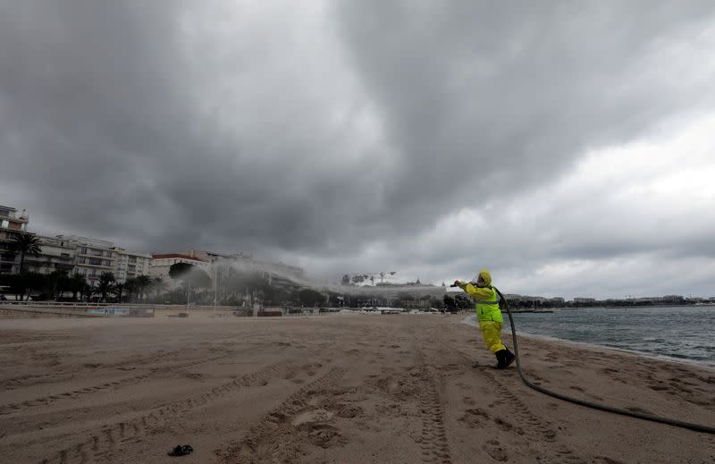 FILE PHOTO: A disinfection squad sprays disinfectant to clean beaches on the Croisette in Cannes