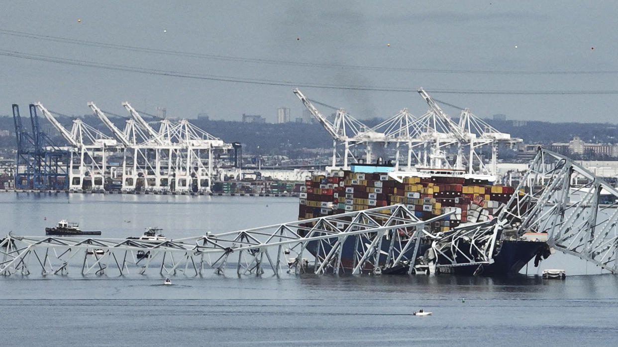 A cargo ship is stuck under the part of the structure of the Francis Scott Key Bridge after the ship hit the bridge Tuesday, March 26, 2024, in Baltimore, Md. (AP Photo/Steve Helber)