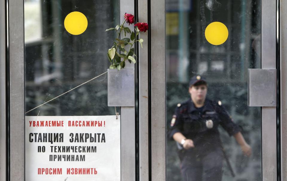 Flowers in memory of victims of Tuesday's accident, in which three carriages derailed on a train during morning rush hour, are left next to a sign informing passengers that the station is closed due to technical reasons, at the entrance to a metro station in Moscow July 16, 2014. Russian state investigators said on Wednesday they had detained two Moscow metro workers suspected of safety breaches that may have caused an accident that killed at least 21 people. (REUTERS/Sergei Karpukhin)