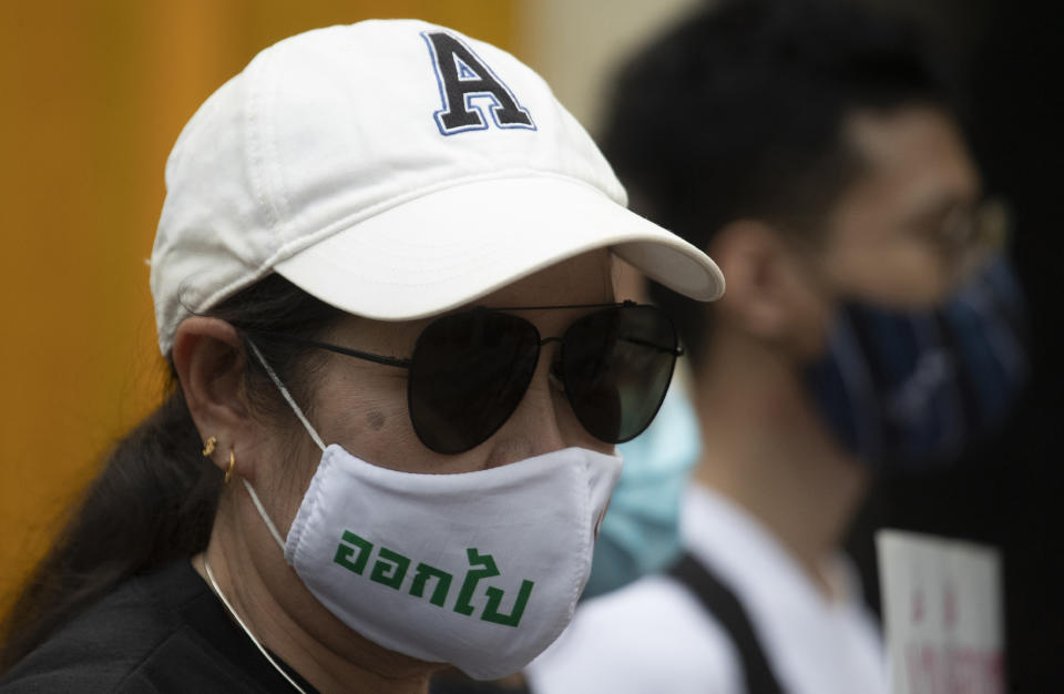 Anti-government protesters wear face masks that read "Get Out" as they gather in front of the Royal Thai Army Headquarters in Bangkok, Thailand, Monday, July 20, 2020. Anti-government protesters are calling for a new constitution, new elections, and an end to repressive laws. (AP Photo/Sakchai Lalit)