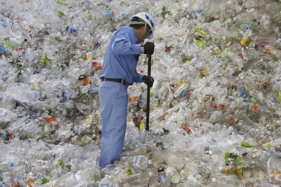 In this June 18, 2019, photo, a plastic recycling company worker sorts out plastic bottles collected for processing at Tokyo Petbottle Recycle Co., Ltd, in Tokyo. Japan has a plastic problem. Single bananas here are sometimes wrapped in plastic. So are individual pieces of vegetables, fruit, pastries, pens and cosmetics. Plastic-wrapped plastic spoons come with every ice cream cup. But as world leaders descend on Osaka for the two-day G20 Summit that starts Friday, June 28, Japan has ambitions to become a world leader in reducing plastic waste. (AP Photo/Koji Sasahara)