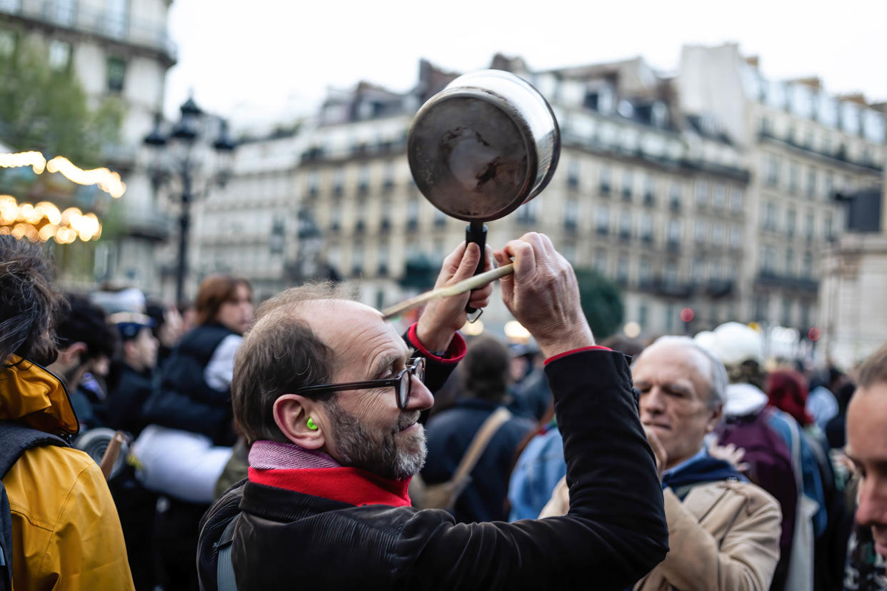 Des manifestants munis de casseroles lors d'une casserolade à Paris, le 24 avril 2023 (Photo by Telmo Pinto/SOPA Images/LightRocket via Getty Images)