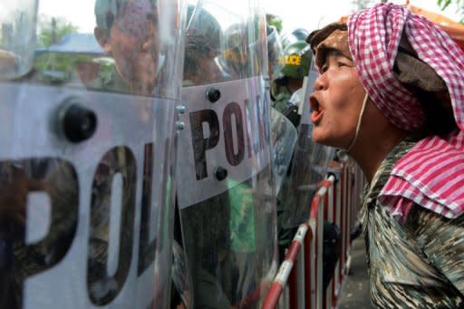 A Cambodian protester shouts slogans in front of anti-riot policemen blocking a road during a protest outside the venue for the Association of Southeast Asian Nations (ASEAN) summit in Phnom Penh. Asian leaders have clashed over how to handle tense maritime territorial disputes with China, overshadowing talks at a regional summit meant to strengthen trade and political ties