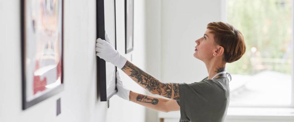 Woman hangs a painting