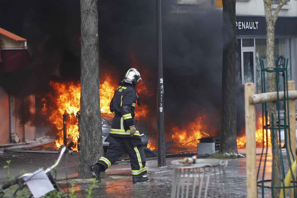 <p>A firefighter walks past burning cars set on fire by activists during the traditional May Day rally in the center of Paris, France, May 1, 2018. Each year, people around the world take to the streets to mark International Workers’ Day, or May Day. (Photo: Francois Mori/AP) </p>