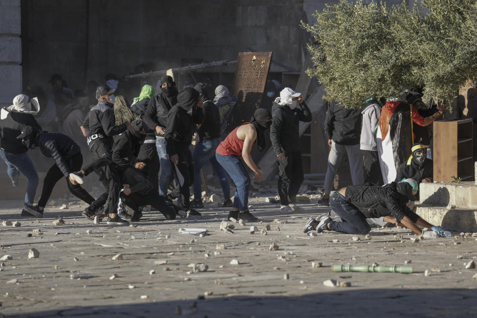 Palestinians clash with Israeli security forces at the Al Aqsa Mosque compound in Jerusalem's Old City Friday, April 15, 2022. (AP Photo/Mahmoud Illean)